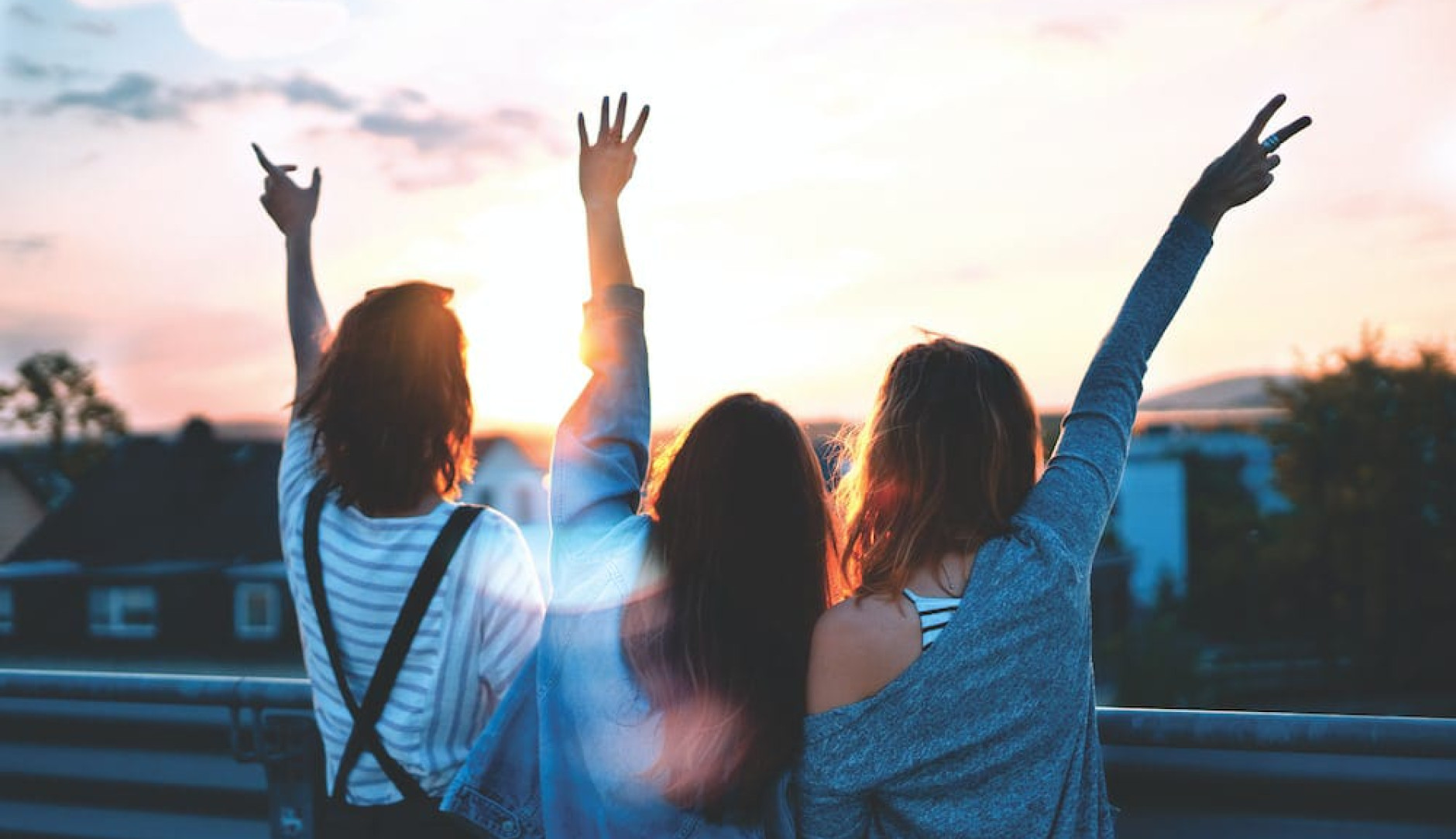 Tres personas jóvenes mirando el atardecer.
